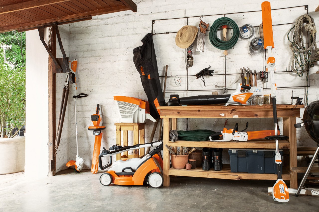 La débroussailleuse à batterie STIHL FSA&nbsp;56 est suspendue à côté des taille-haies à batterie HSA&nbsp;56 et HLA&nbsp;56 et de la tondeuse à gazon à batterie RMA&nbsp;339