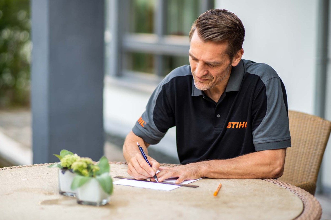 Revendeur STIHL dessinant la zone de tonte d’un robot tondeuse iMOW® 422 STIHL