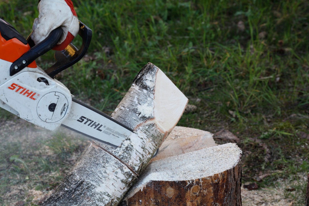 Fabriquer des bougies en bois : une tronçonneuse STIHL MSA 140 C utilisée pour sculpter une forme de flamme dans un rondin