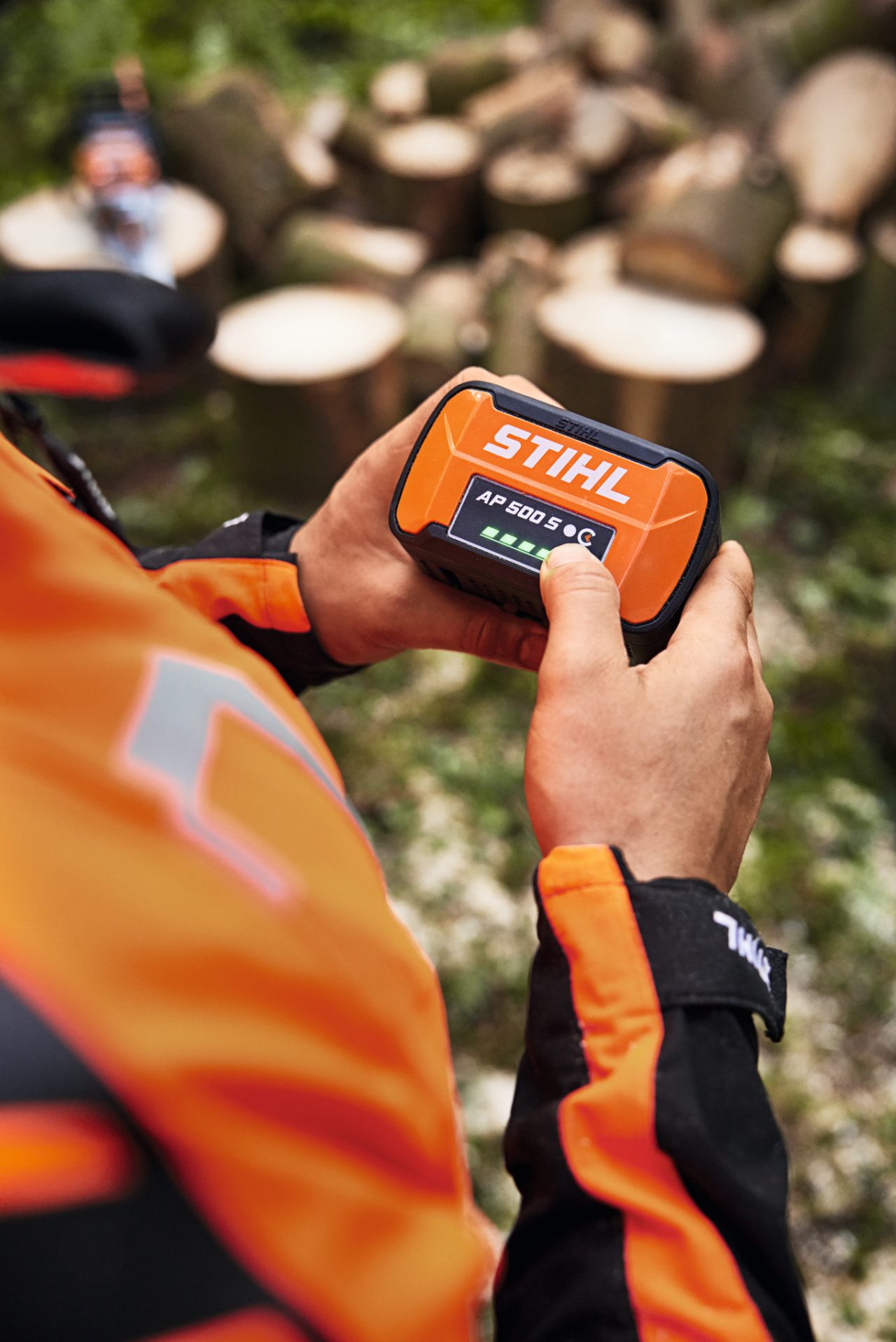 Gros plan d'une personne avec la batterie lithium-ion STIHL AP 500 S dans les mains.