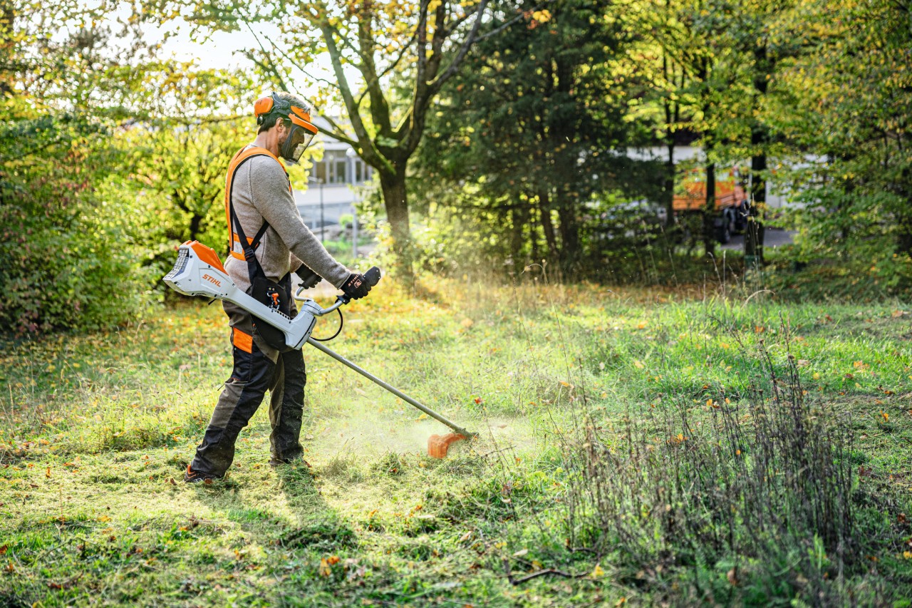 Mann mit Akku-Motorsense STIHL FSA 200 mit Zweihandgriff