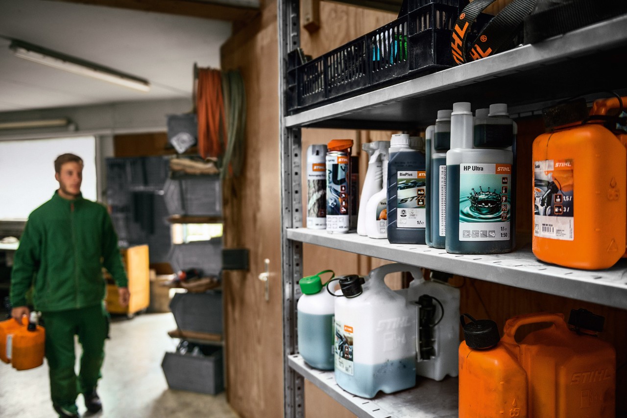 Carburants et lubrifiants STIHL rangés sur des étagères