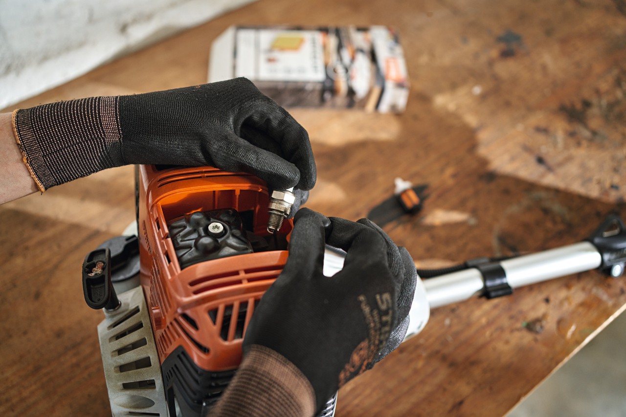 Gros plan sur le remplacement de la bougie d’un coupe-haies STIHL