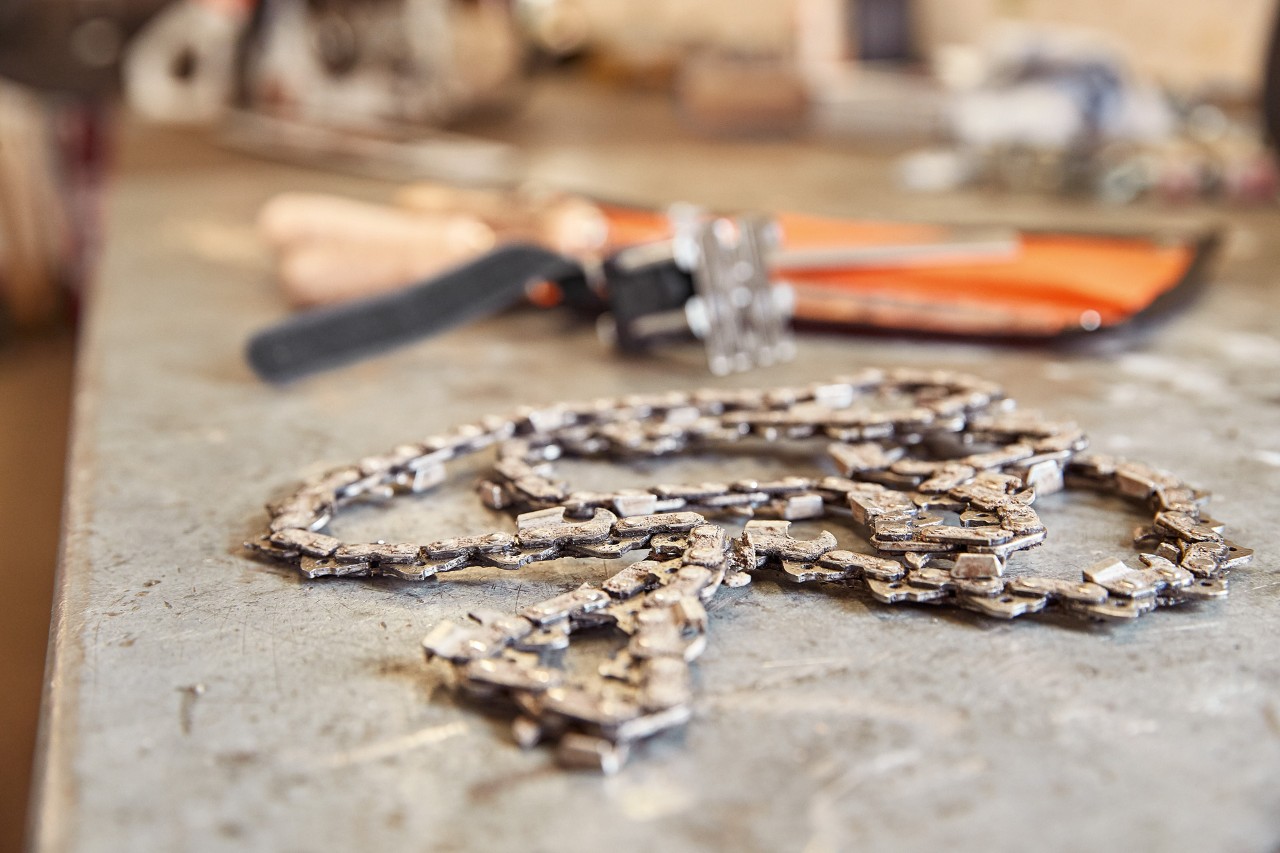 Chaîne de tronçonneuse STIHL et ses outils sur un établi