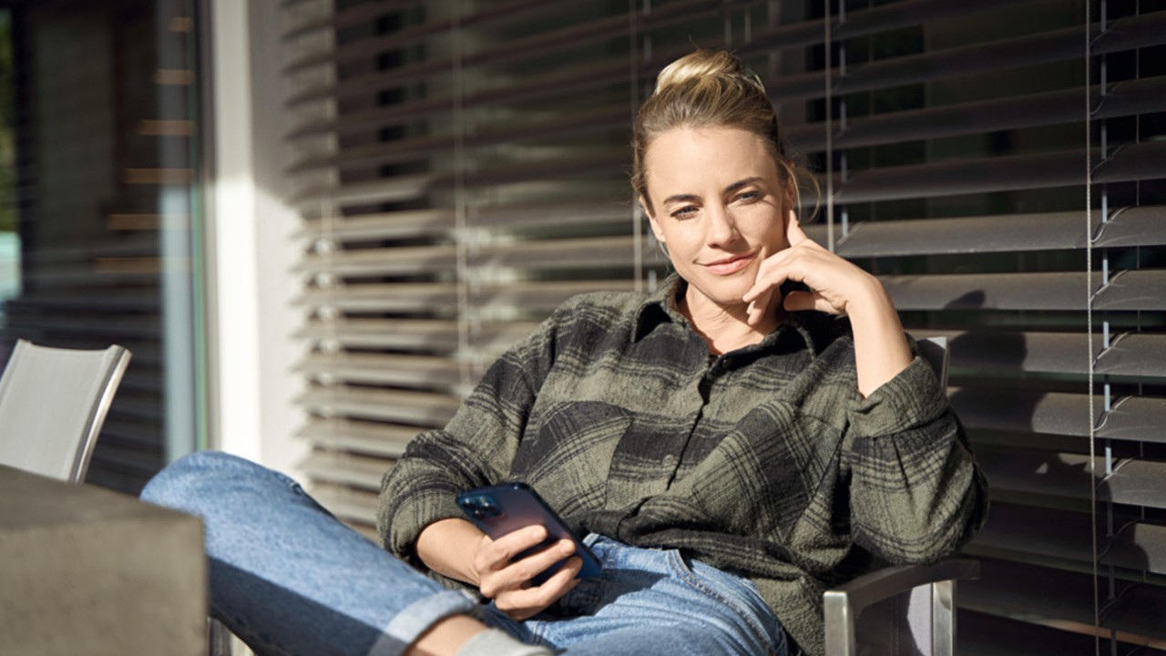 Uen femme assise sur sa terrasse au soleil